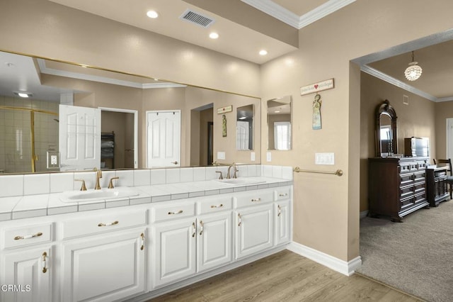 bathroom featuring baseboards, a sink, visible vents, and crown molding