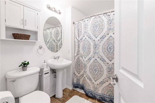 bathroom with toilet and curtained shower