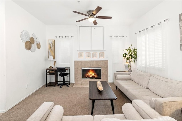 living room featuring carpet, a fireplace, baseboards, and a ceiling fan