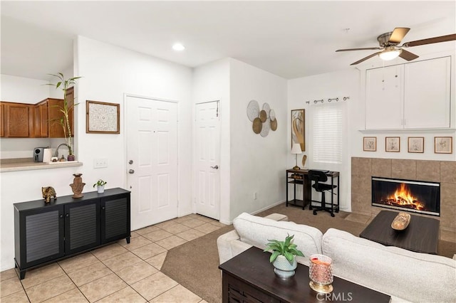 living room with a ceiling fan, recessed lighting, a tiled fireplace, and light tile patterned floors