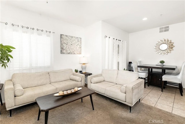 living area featuring light tile patterned flooring, visible vents, and recessed lighting