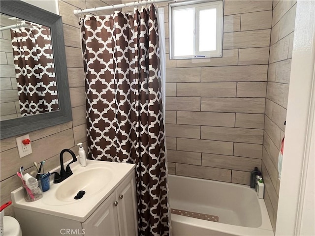 bathroom featuring shower / bath combo with shower curtain and vanity