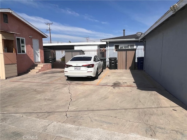 view of vehicle parking with fence