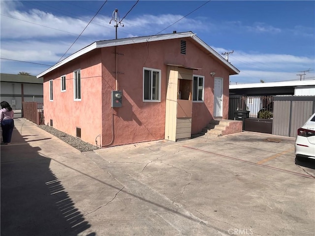 view of property exterior with fence and stucco siding