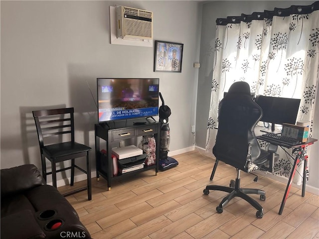 office featuring wood finish floors, a wall mounted air conditioner, and baseboards