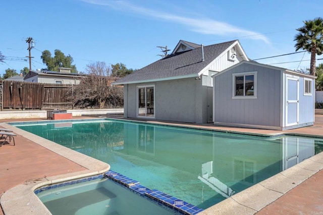 view of swimming pool with a fenced in pool, an outbuilding, fence, and an in ground hot tub