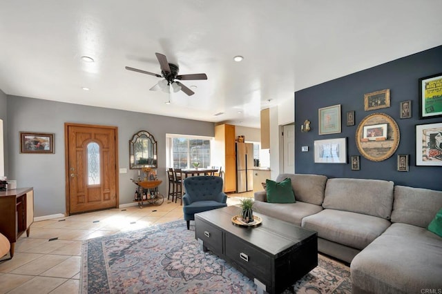 living room featuring ceiling fan, baseboards, and light tile patterned flooring