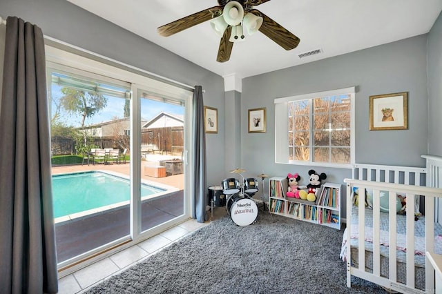 bedroom featuring access to exterior, tile patterned flooring, visible vents, and a ceiling fan