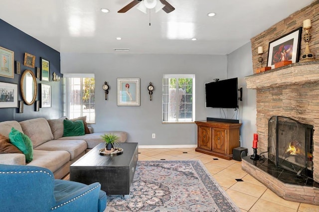 living area featuring a healthy amount of sunlight, light tile patterned flooring, a fireplace, and visible vents