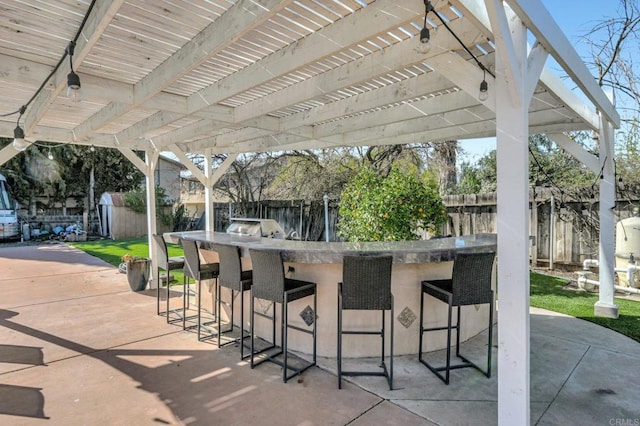 view of patio / terrace with a pergola, a fenced backyard, an outdoor structure, and a storage unit