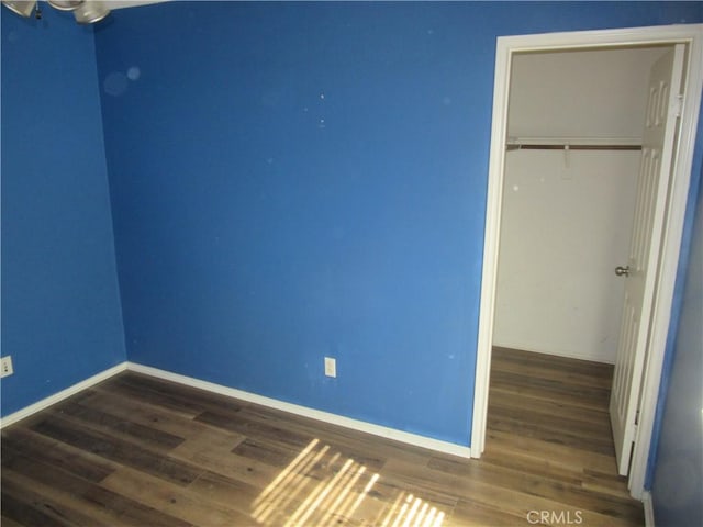 unfurnished bedroom featuring a closet, baseboards, and wood finished floors