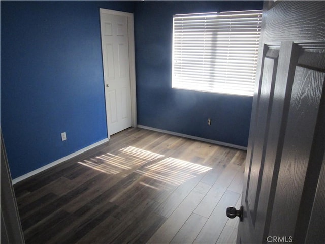 unfurnished bedroom with baseboards and wood finished floors