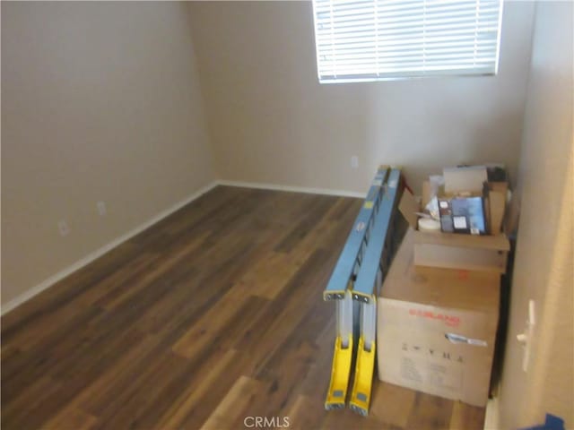 unfurnished room featuring baseboards and wood finished floors