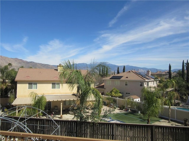 back of property featuring a patio area, a tile roof, a mountain view, and stucco siding