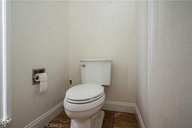 bathroom with toilet and baseboards