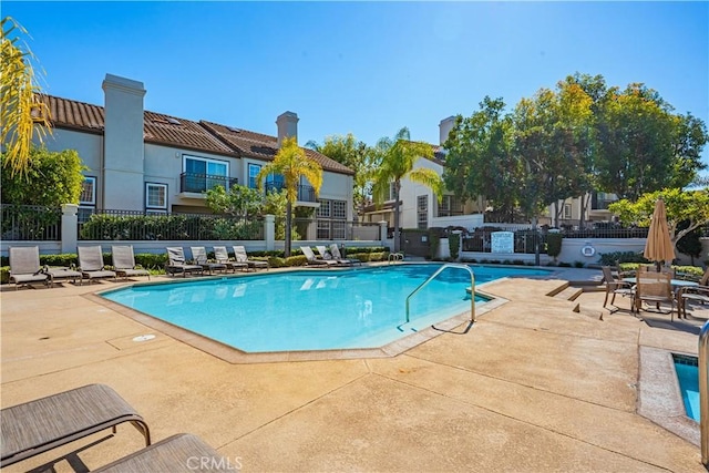 pool featuring fence and a patio