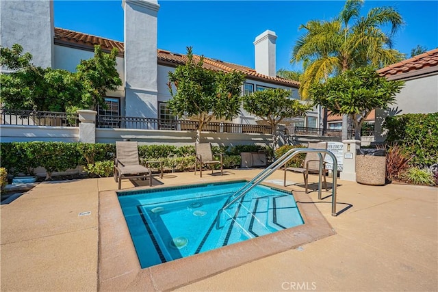 view of swimming pool with a swimming pool, fence, and a patio