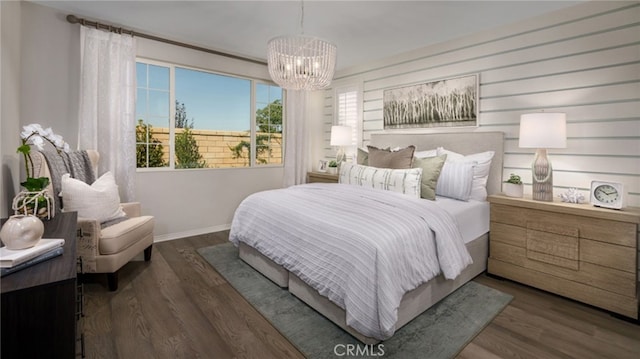 bedroom featuring baseboards, dark wood-type flooring, and an inviting chandelier