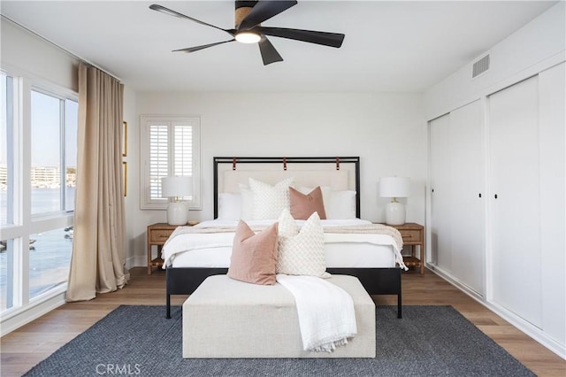 bedroom featuring visible vents, ceiling fan, and wood finished floors