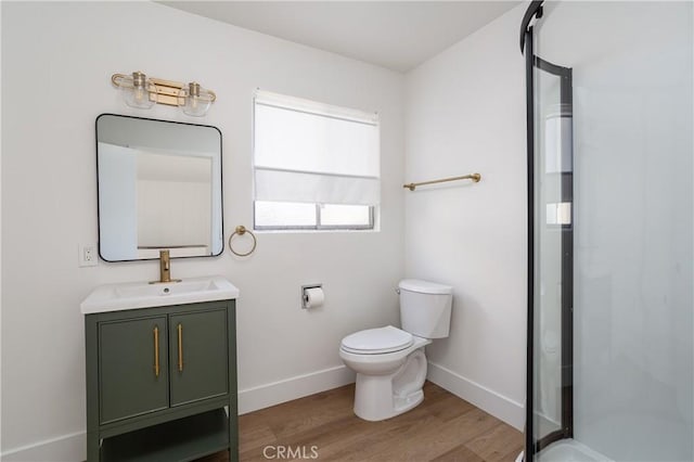 full bathroom with toilet, wood finished floors, a stall shower, vanity, and baseboards