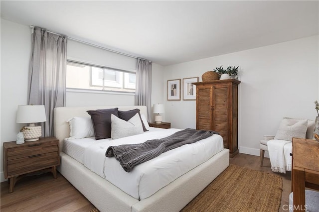 bedroom with baseboards and wood finished floors