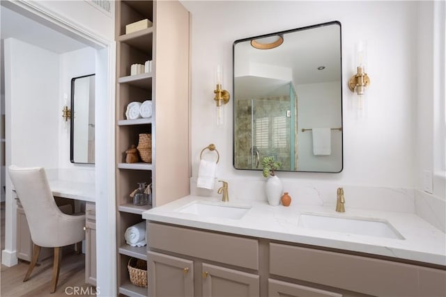 bathroom featuring visible vents, a shower with door, a sink, and double vanity