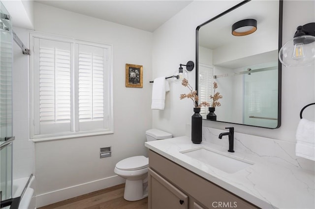 full bathroom with toilet, vanity, wood finished floors, and baseboards