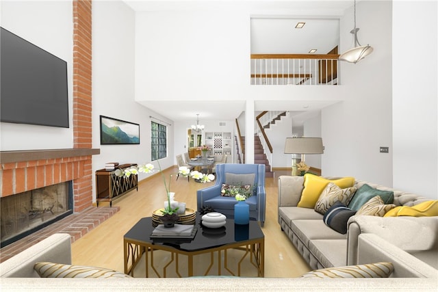 living area with a towering ceiling, stairway, wood finished floors, a fireplace, and a notable chandelier