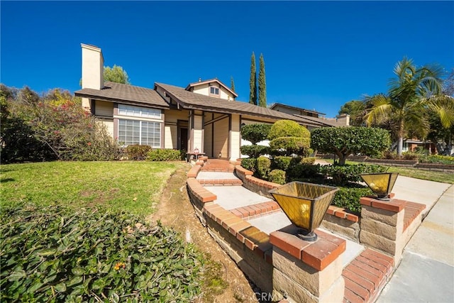 49 Village Loop Rd, Pomona, CA 91766 - view of front facade with a front lawn and a chimney