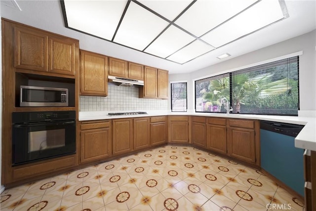 49 Village Loop Rd, Pomona, CA 91766 - kitchen featuring black oven, stainless steel microwave, dishwasher, under cabinet range hood, and light countertops