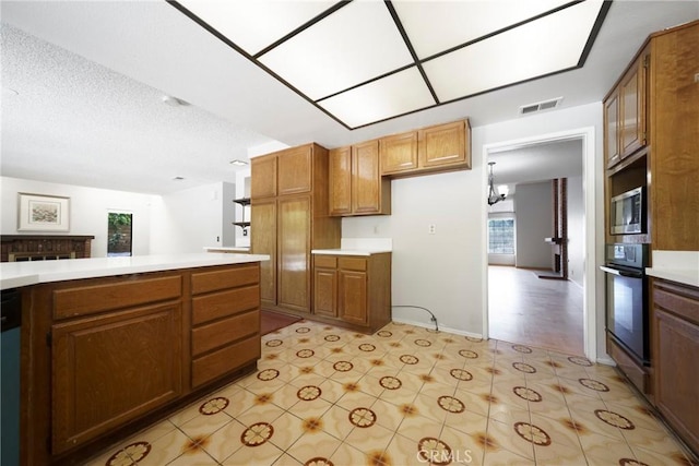 49 Village Loop Rd, Pomona, CA 91766 - kitchen featuring light countertops, brown cabinetry, and stainless steel microwave