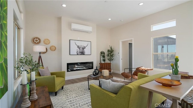 living area featuring a wall mounted air conditioner, a glass covered fireplace, light wood-style flooring, and recessed lighting