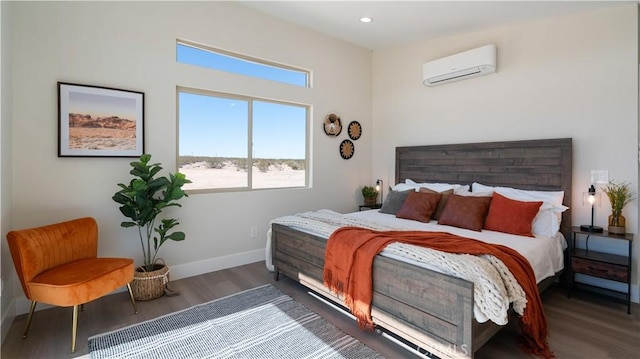 bedroom featuring recessed lighting, baseboards, wood finished floors, and a wall mounted air conditioner