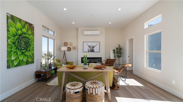 interior space featuring a wall mounted AC, recessed lighting, wood finished floors, and baseboards