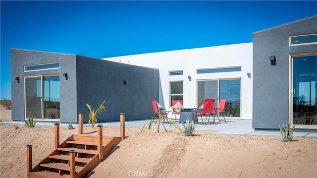 back of house featuring a patio area and stucco siding