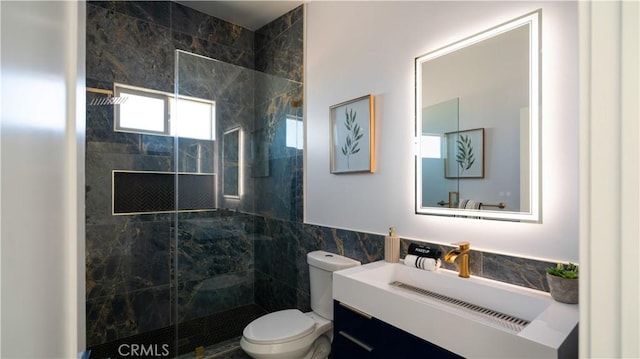 bathroom with a walk in shower, vanity, toilet, and tile walls