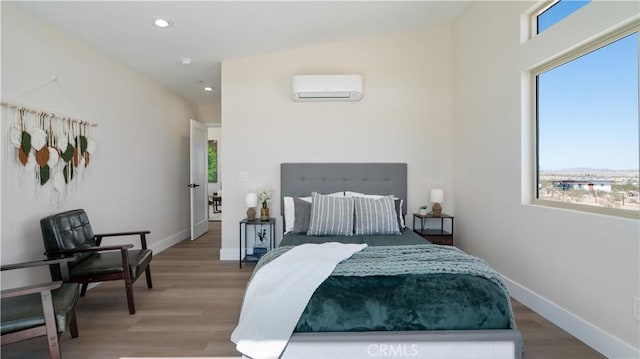 bedroom featuring baseboards, an AC wall unit, wood finished floors, and recessed lighting