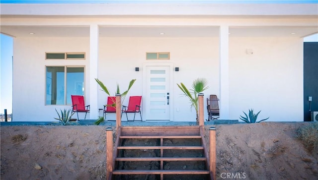 property entrance with visible vents and stucco siding