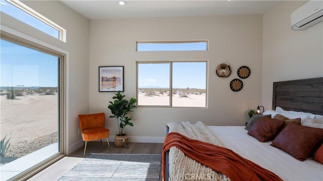 bedroom with baseboards, wood finished floors, access to outside, a wall mounted AC, and recessed lighting