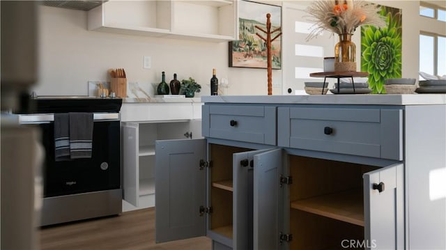 kitchen with open shelves, wood finished floors, and light countertops