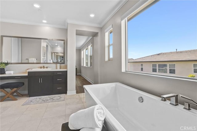 full bath with a freestanding tub, recessed lighting, crown molding, and vanity