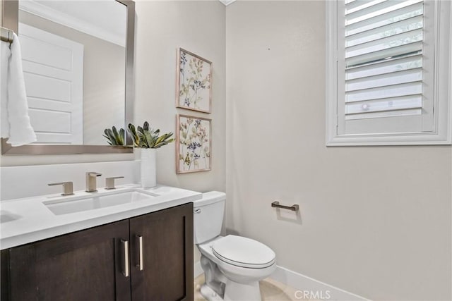 half bath with baseboards, vanity, and toilet