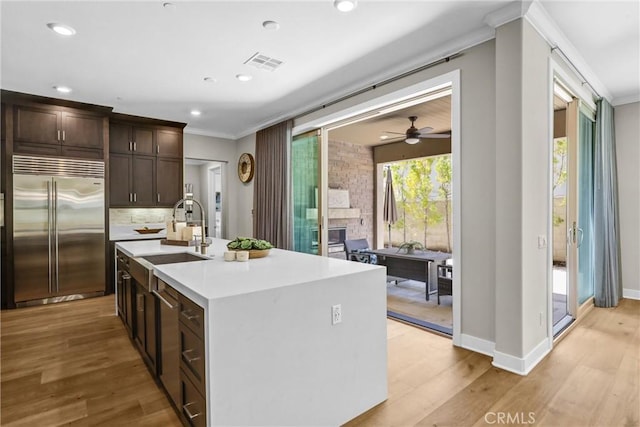 58 Sagan Way, Irvine, CA 92618 - kitchen with built in refrigerator, a sink, crown molding, light countertops, and dark brown cabinetry