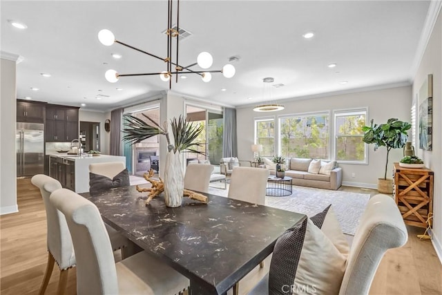 dining room featuring light wood-style floors, visible vents, ornamental molding, and recessed lighting