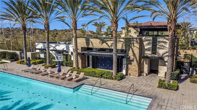 pool featuring a patio and a bar