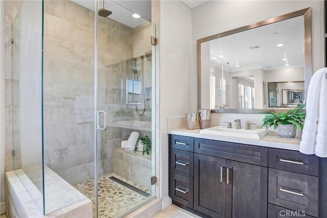 bathroom with visible vents, crown molding, vanity, a shower stall, and recessed lighting