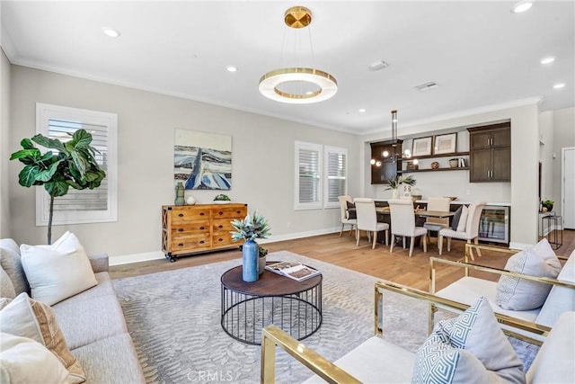 living room with crown molding, visible vents, light wood-type flooring, beverage cooler, and baseboards