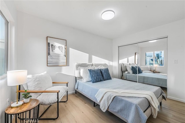 bedroom featuring baseboards, a closet, and light wood-style floors