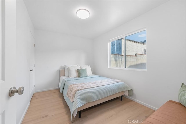 bedroom with wood finished floors and baseboards