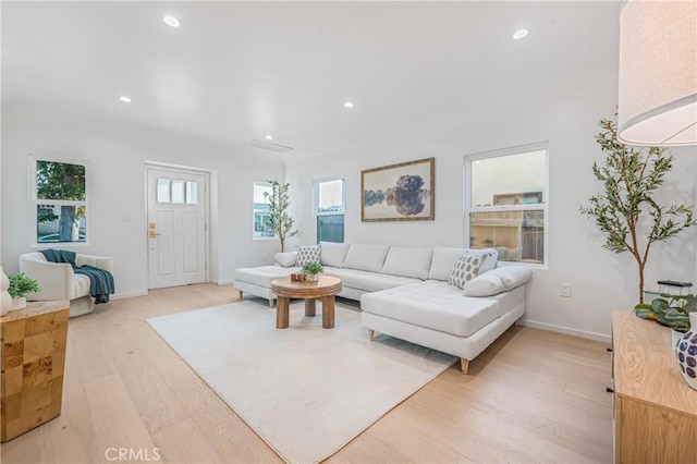 living room featuring recessed lighting, baseboards, and light wood-style flooring